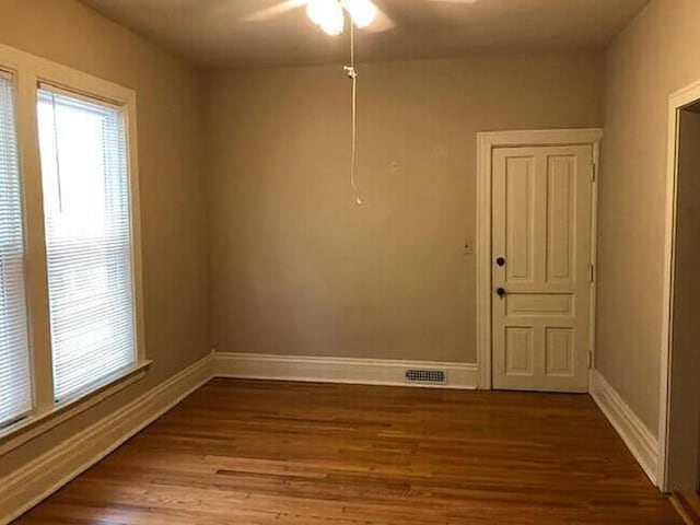 unfurnished room with ceiling fan and dark wood-type flooring