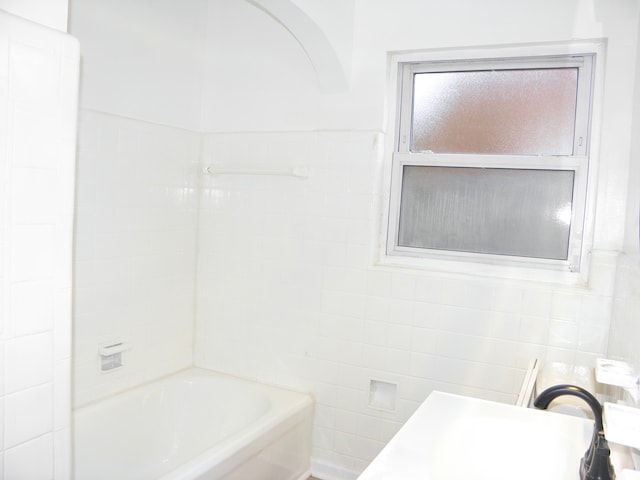 bathroom with sink and tile walls