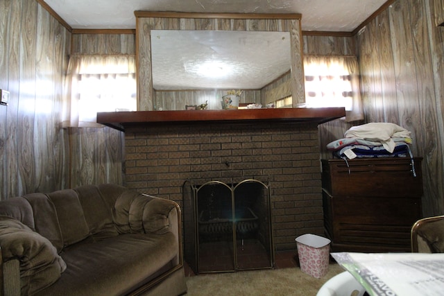 carpeted living room featuring wood walls, crown molding, and a fireplace