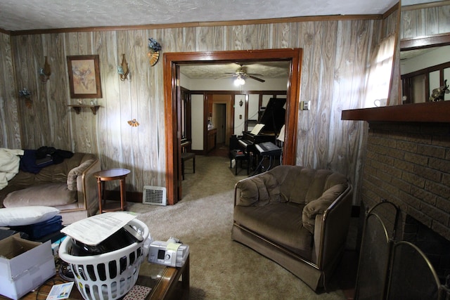 living room with ceiling fan, a fireplace, a textured ceiling, and wooden walls