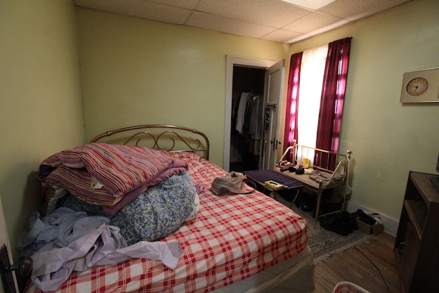 bedroom featuring a drop ceiling, a walk in closet, and a closet