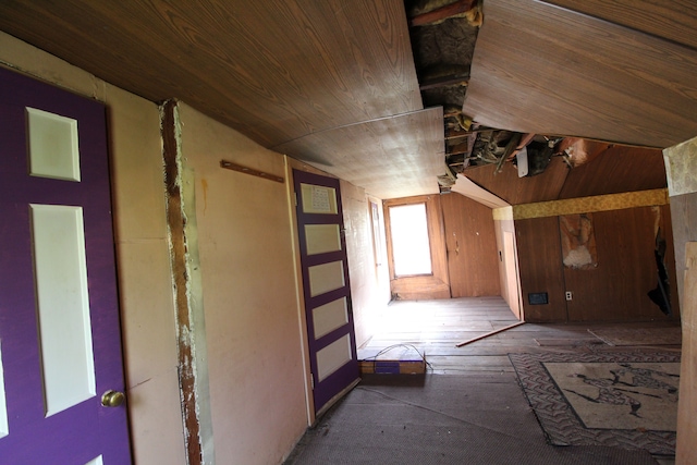 interior space with wood walls, lofted ceiling, and wooden ceiling