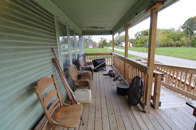 deck featuring a porch and a lawn