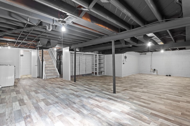 basement featuring wood-type flooring and washer / dryer