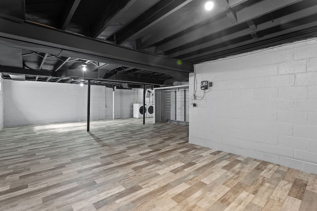 basement featuring washer and clothes dryer and hardwood / wood-style flooring