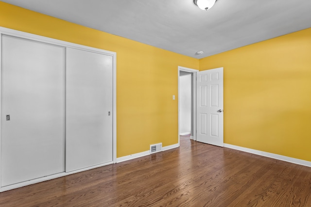 unfurnished bedroom with a closet and wood-type flooring