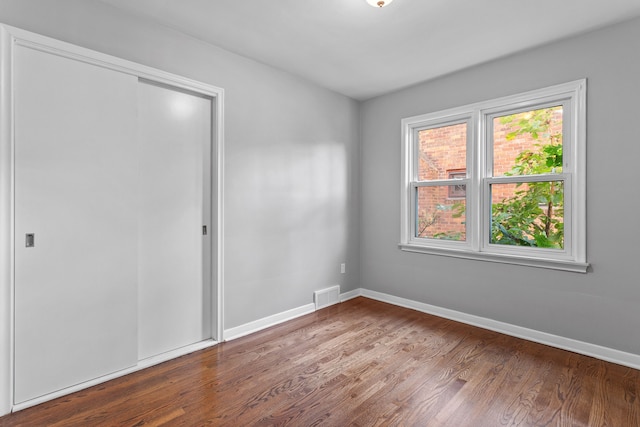 unfurnished bedroom with a closet and wood-type flooring