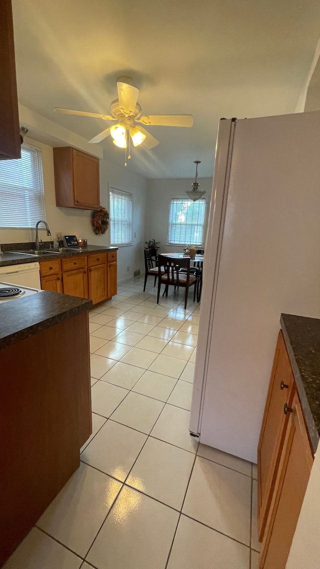 kitchen with a wealth of natural light, ceiling fan, light tile patterned flooring, and white refrigerator