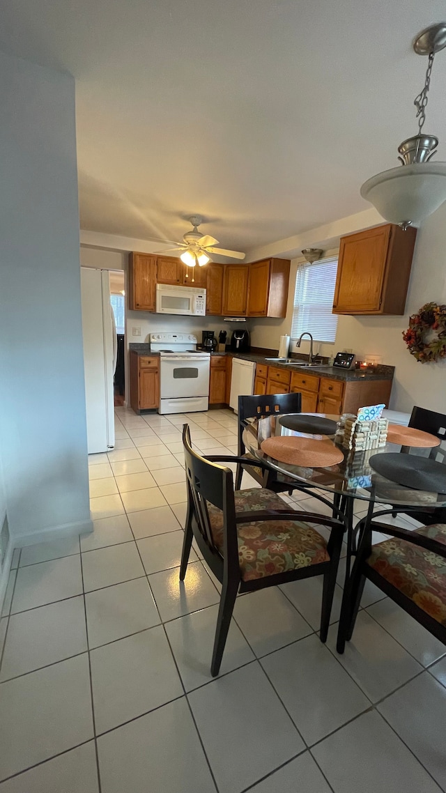 tiled dining area featuring ceiling fan and sink