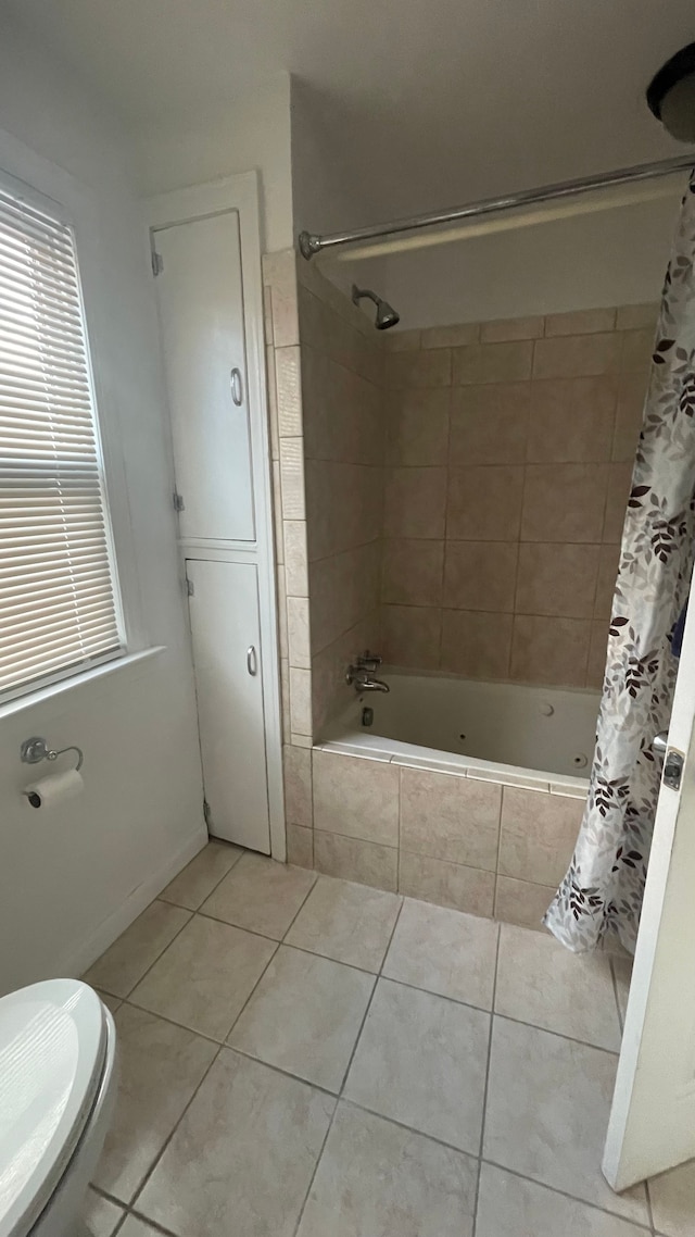 bathroom with tile patterned floors, shower / tub combo with curtain, and toilet