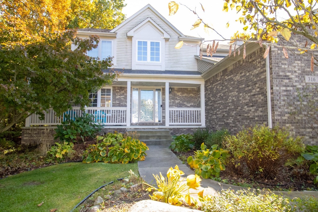 view of front of property with covered porch and a front lawn