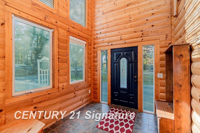 entryway with log walls and a towering ceiling