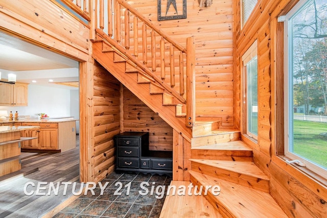 stairway featuring hardwood / wood-style floors and rustic walls