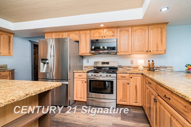 kitchen featuring light stone countertops, light brown cabinetry, dark hardwood / wood-style floors, and appliances with stainless steel finishes