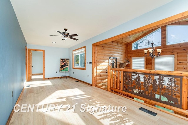 interior space featuring hardwood / wood-style flooring, a notable chandelier, and vaulted ceiling