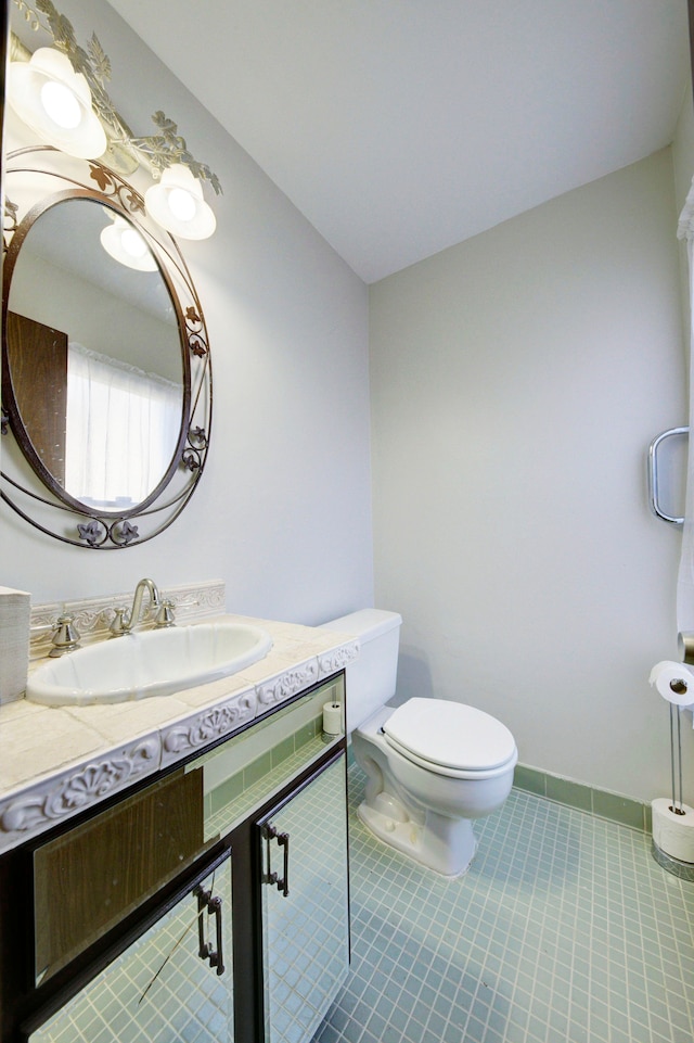 bathroom with tile patterned flooring, vanity, and toilet