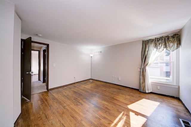 unfurnished room with hardwood / wood-style flooring