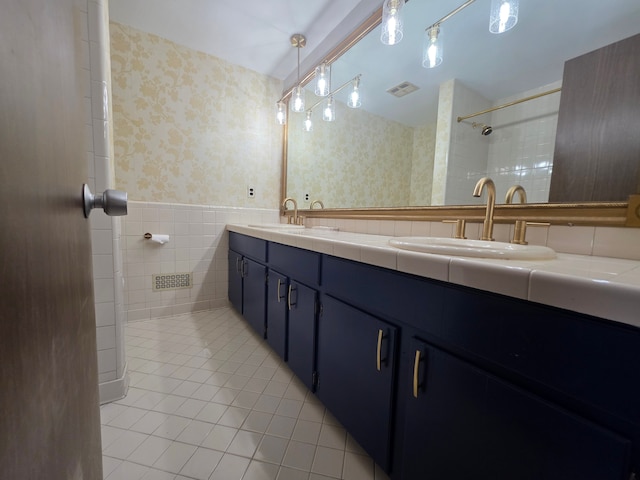 bathroom with wallpapered walls, visible vents, tile patterned flooring, and a sink