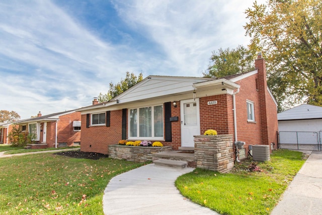 single story home with central AC and a front yard