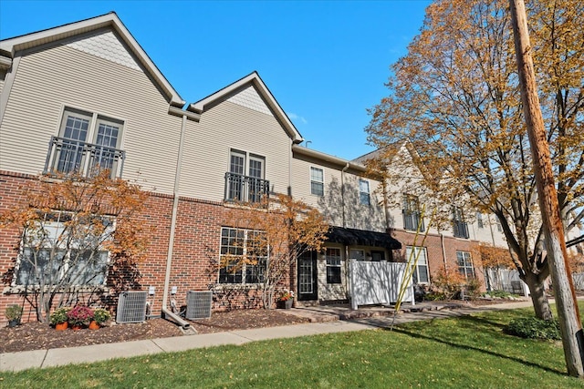 rear view of house featuring a yard and central air condition unit