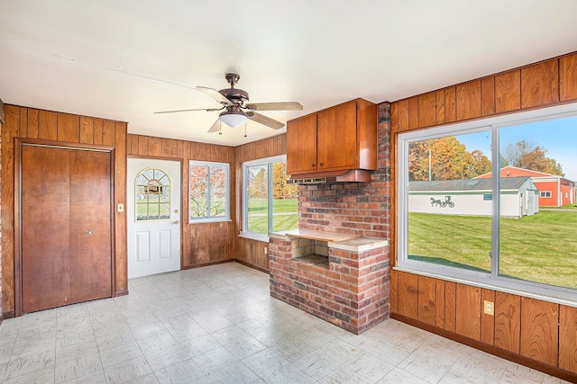 kitchen featuring ceiling fan and wood walls