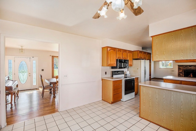 kitchen with pendant lighting, a healthy amount of sunlight, white appliances, and light wood-type flooring