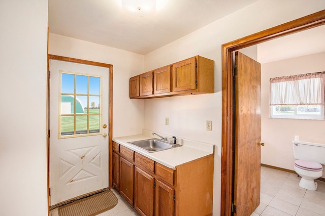 kitchen with sink, light tile patterned flooring, and a healthy amount of sunlight