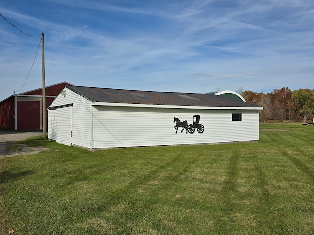 view of side of home featuring a yard and an outbuilding