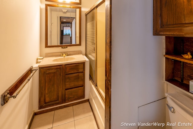 full bathroom featuring tile patterned flooring, vanity, toilet, and enclosed tub / shower combo