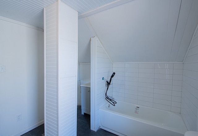 bathroom with a tub and lofted ceiling