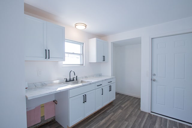 kitchen featuring white cabinets, light stone countertops, sink, and dark wood-type flooring