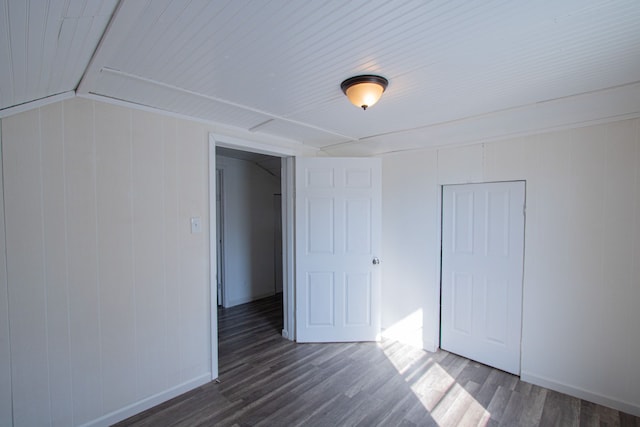 unfurnished bedroom with dark wood-type flooring and a closet