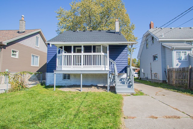 back of property featuring a yard and a sunroom