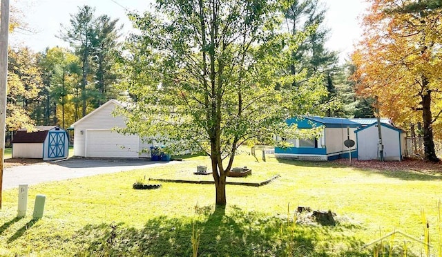 view of yard featuring a garage and a storage unit