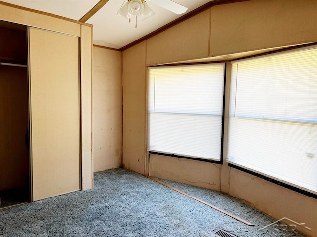 unfurnished bedroom featuring ornamental molding, carpet floors, ceiling fan, and lofted ceiling