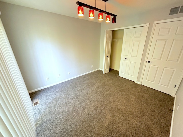 unfurnished bedroom featuring dark carpet