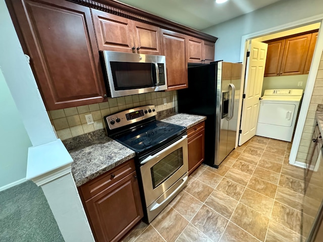 kitchen featuring decorative backsplash, dark stone countertops, washer / clothes dryer, and appliances with stainless steel finishes