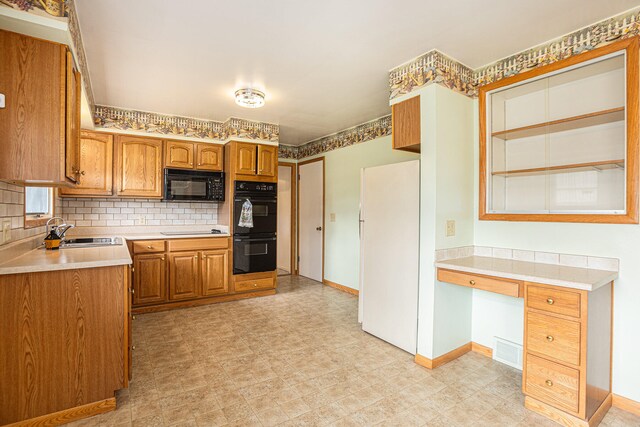 kitchen with black appliances, sink, and tasteful backsplash