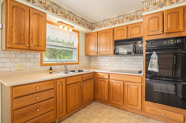 kitchen featuring black appliances, backsplash, and sink