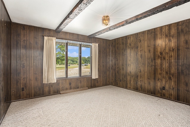 unfurnished room with wood walls and beam ceiling