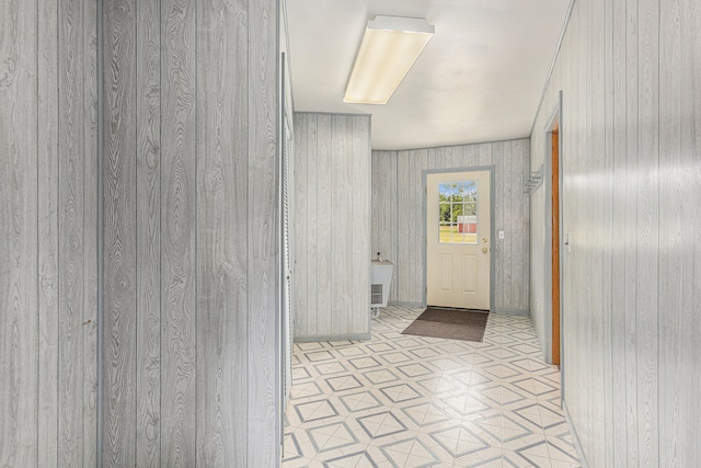 hallway featuring light tile patterned floors and wooden walls