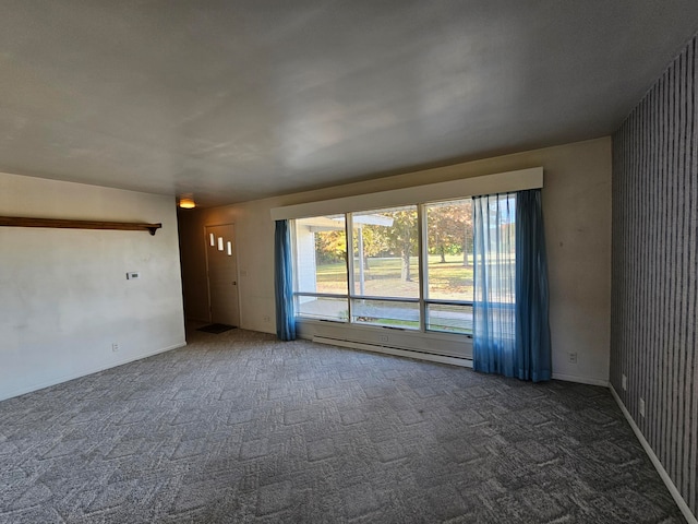 interior space with dark colored carpet and a baseboard heating unit