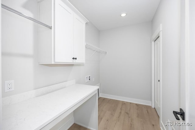 laundry area featuring light wood-style flooring, recessed lighting, washer hookup, baseboards, and cabinet space