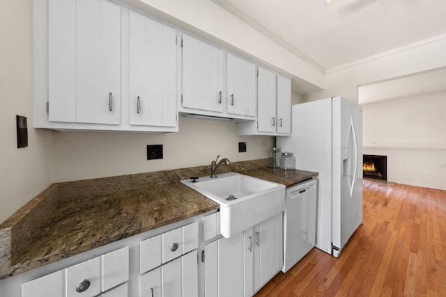 kitchen featuring light wood-type flooring, ornamental molding, sink, dishwasher, and white cabinetry