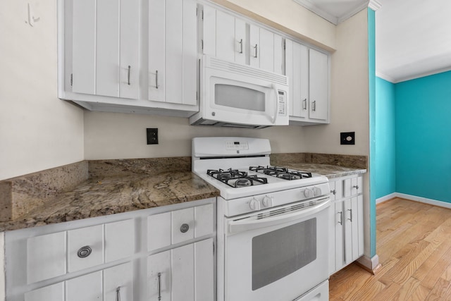 kitchen featuring light wood-type flooring, white appliances, crown molding, dark stone countertops, and white cabinetry