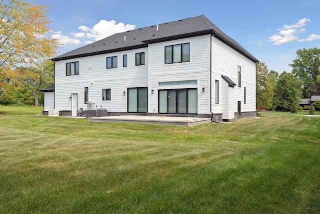 rear view of property featuring a yard, central AC unit, and a patio area