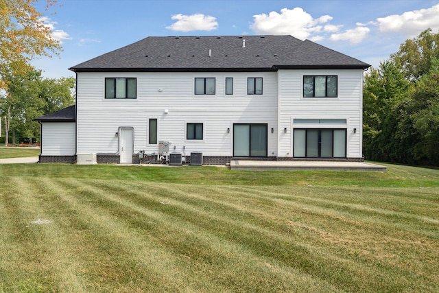 back of house featuring a lawn, central air condition unit, and a patio