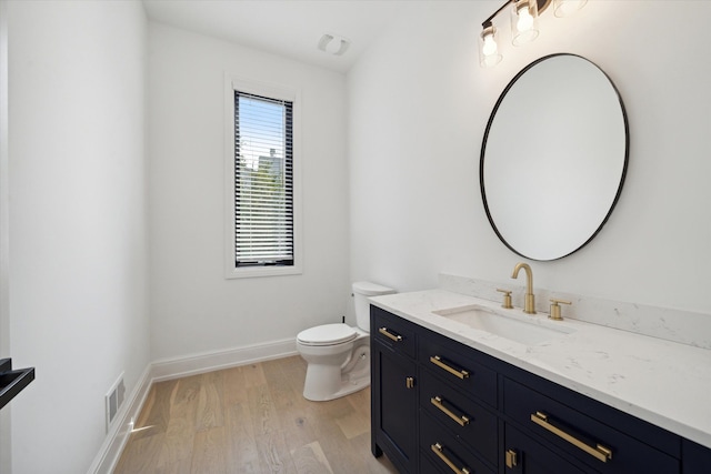 bathroom featuring toilet, vanity, and hardwood / wood-style flooring