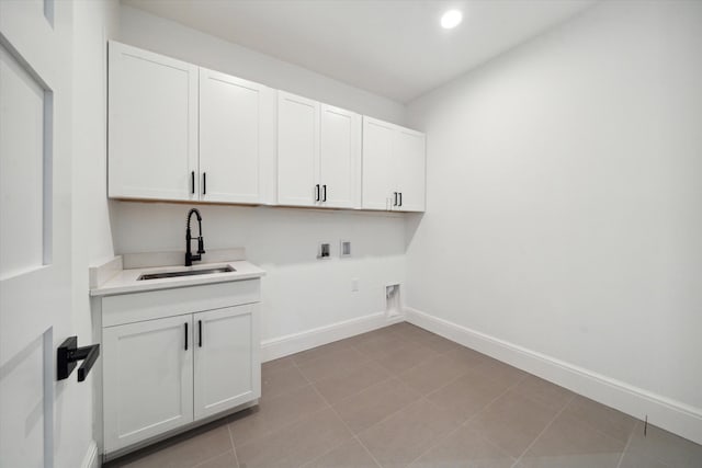 laundry area featuring hookup for an electric dryer, washer hookup, cabinets, sink, and light tile patterned floors