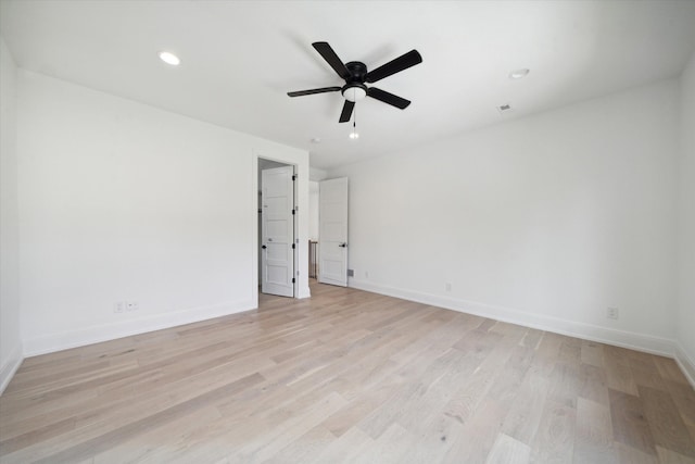 empty room with ceiling fan and light hardwood / wood-style flooring